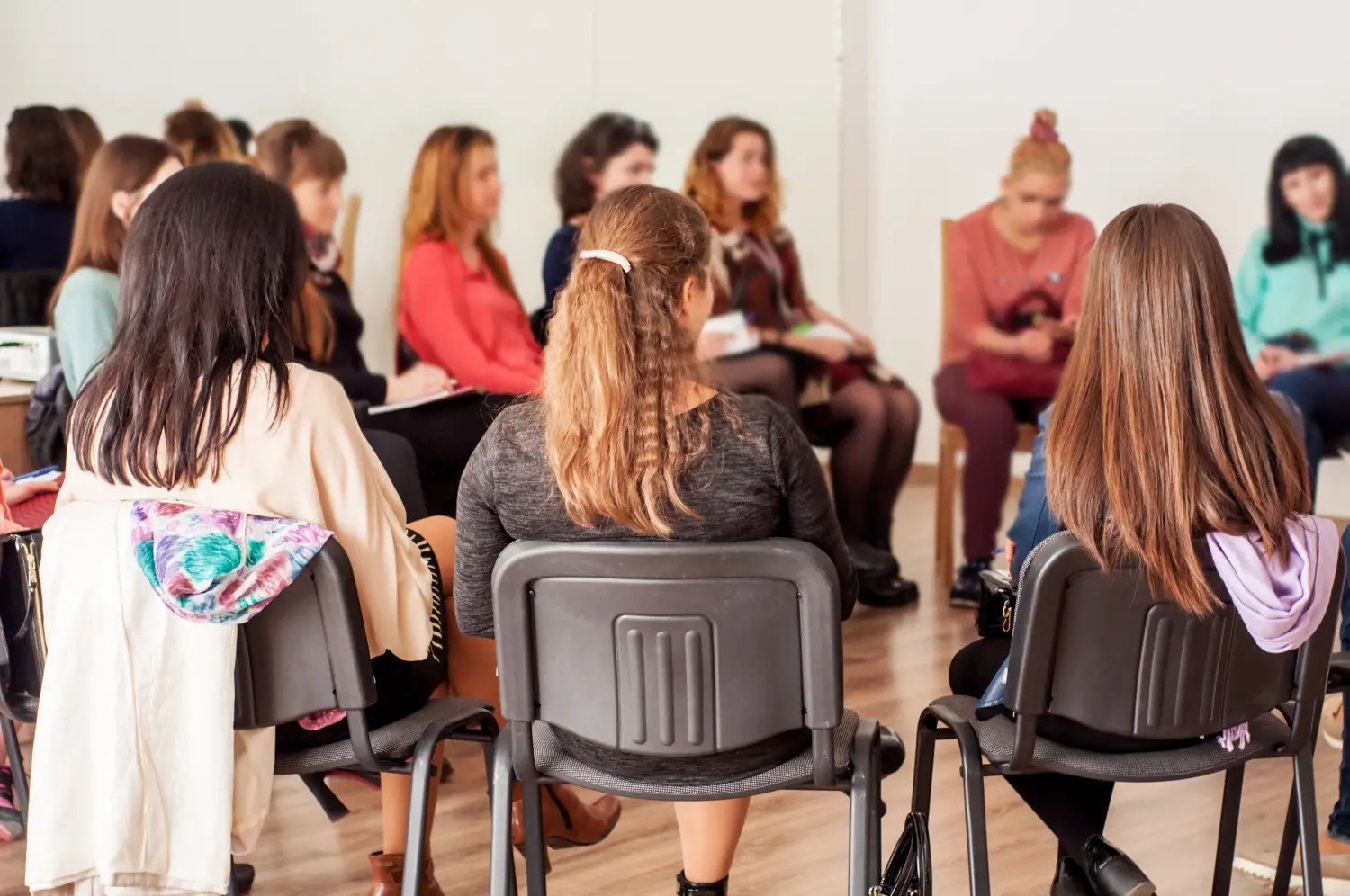 Gruppe junger Frauen, die sich im Kreis sitzend unterhalten. Psychologische Unterstützung
