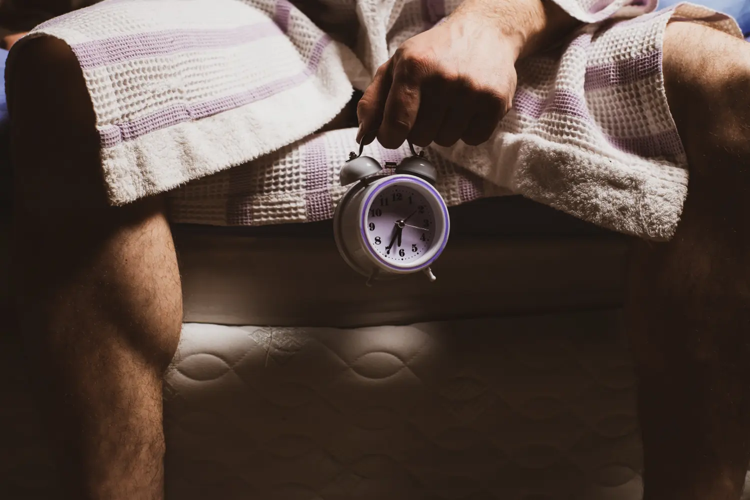 Andropause Konzept. Wecker zwischen männlichen Beinen. Männliche Menopause, Impotenz, biologische Uhr.